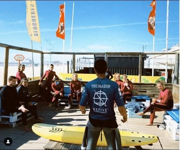 Instructor briefing a surf group on a beachfront deck