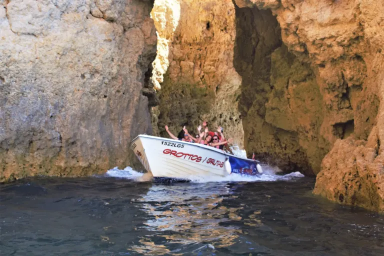 Boat with passengers entering a rocky cave opening