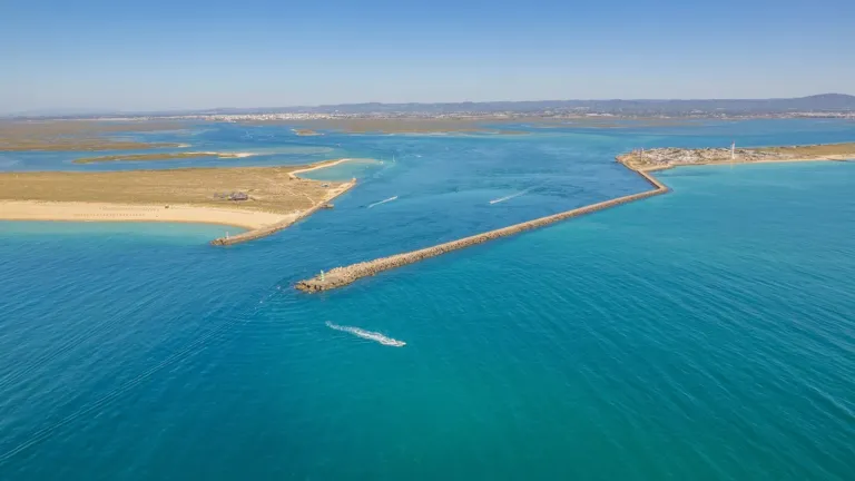 Aerial view of a channel with breakwaters at the mouth of a lagoon