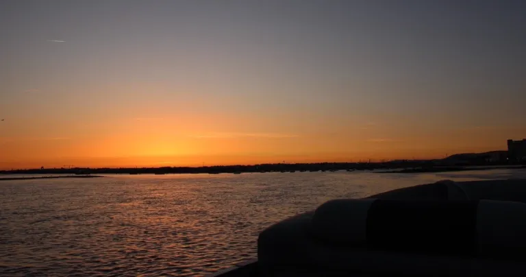 Orange glow of sunset over calm water