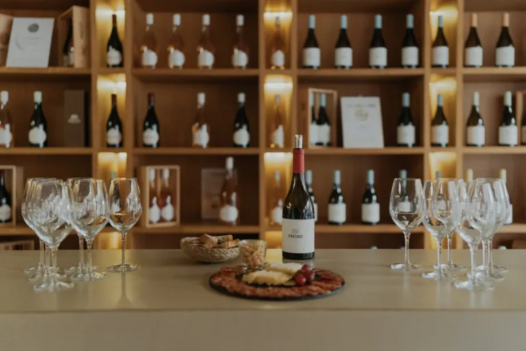 Tasting counter with wine bottles, glasses and a cheese platter
