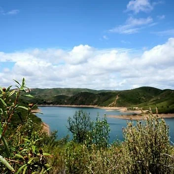 Wooded hills and a blue reservoir seen from a viewpoint