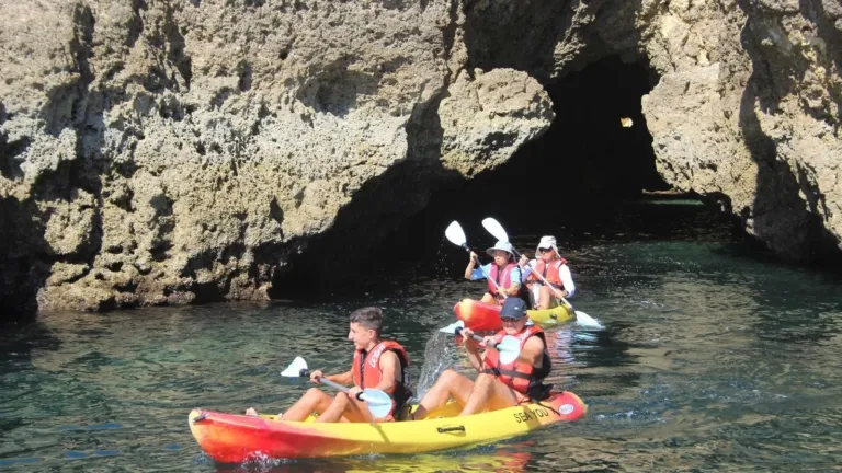 Kayakers paddling into a sea cave entrance