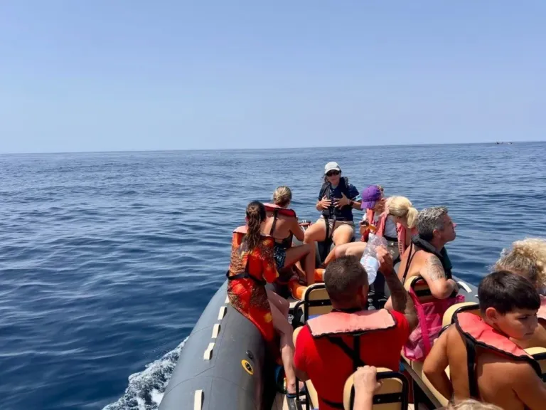 Passengers in life jackets on a rigid inflatable boat out at sea